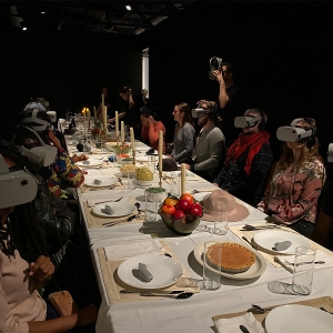 在费城Wonderspaces,学生们戴着虚拟现实头盔围坐在餐桌旁。