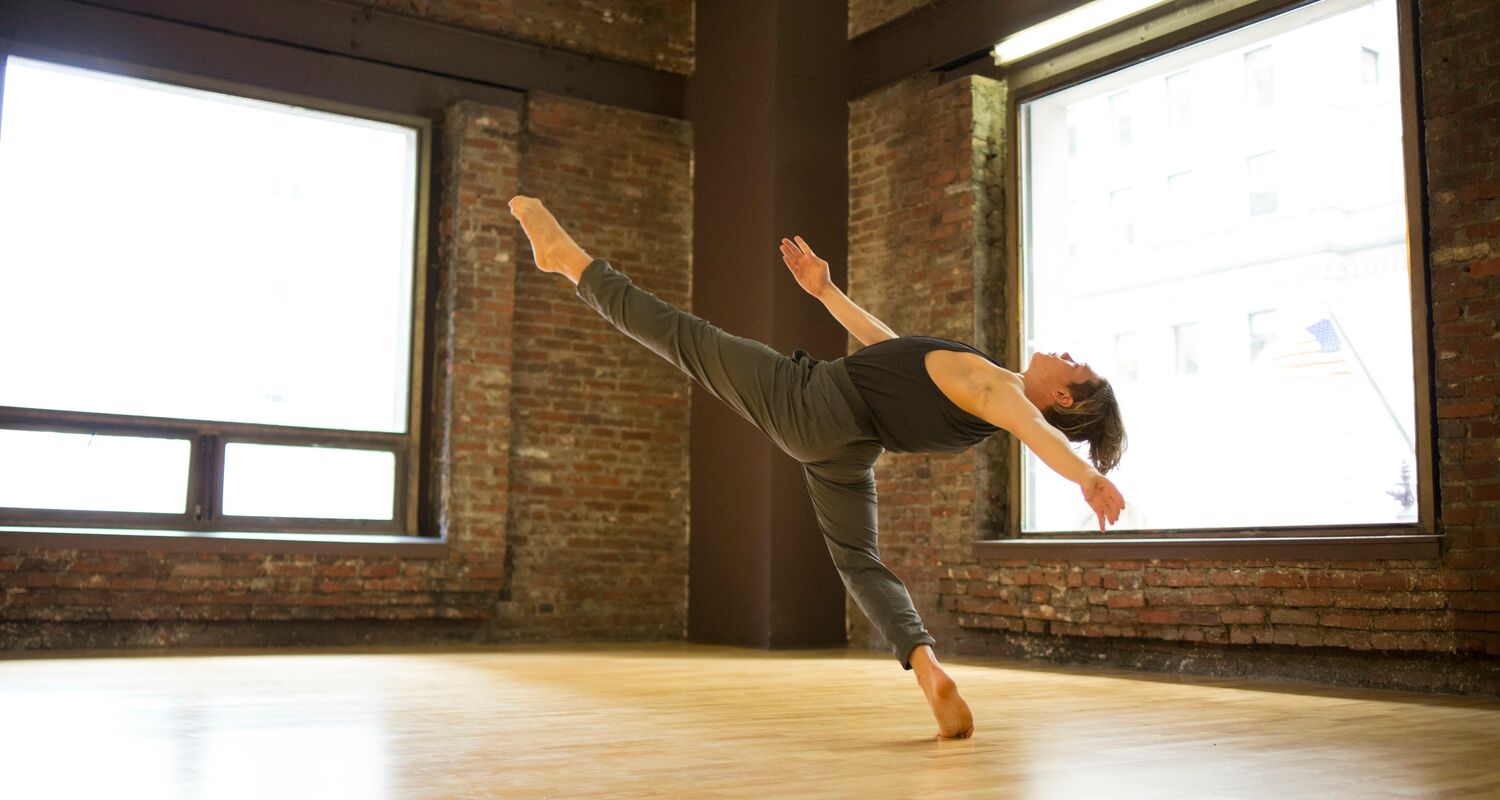 舞者将腿延伸到舞蹈工作室的空中。