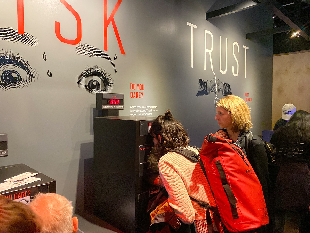 教师会员Stephanie Reyer和学生看着国际间谍博物馆的互动展览。