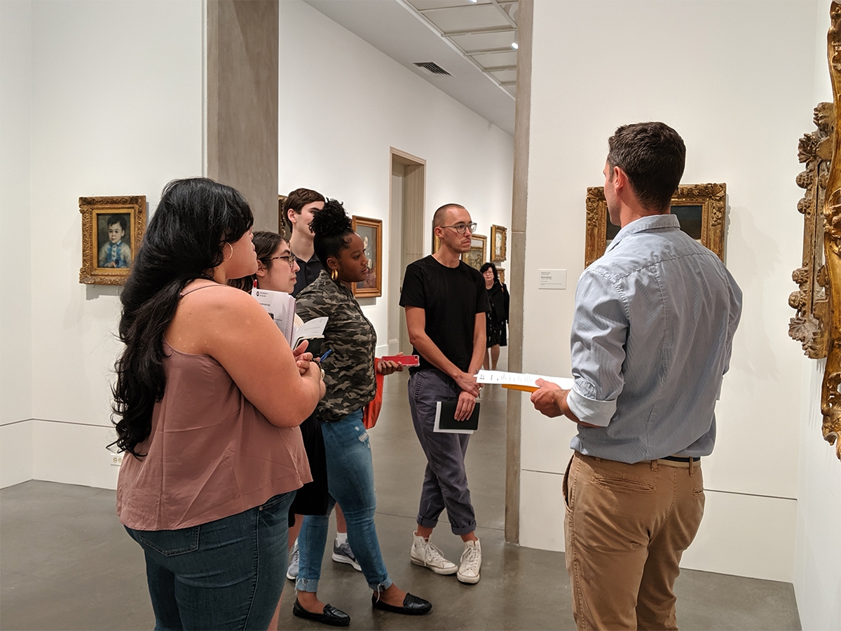 在费城艺术博物馆的一件艺术品前，教职员Mickey Maley和学生们交谈。
