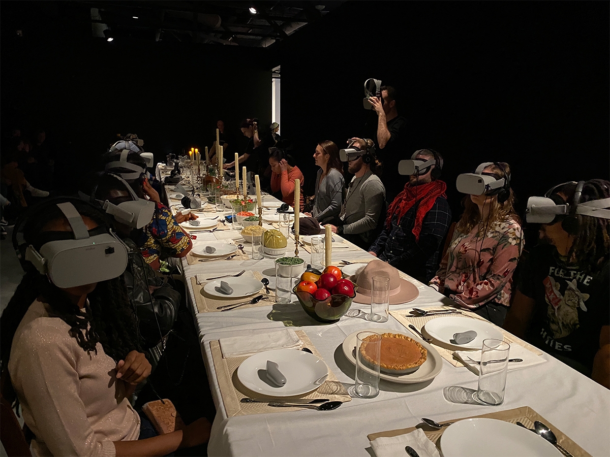 学生坐在一张餐桌周围，在Wonderspaces费城的虚拟现实头饰。