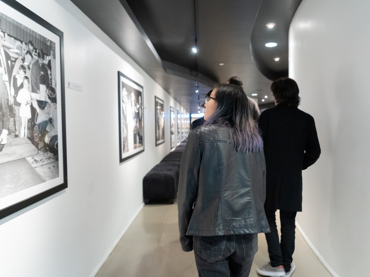 学生走在一个走廊里，看看TCL中国剧院墙上的照片。