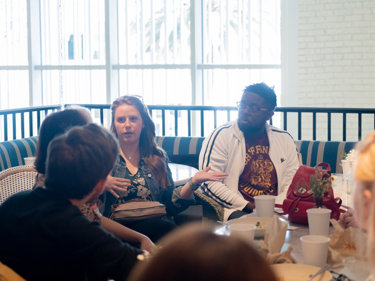 学生和教师坐在一张早午餐的桌子上，与校友Lauren Deacon BFA '09（WFTV）和Darnell Brown Darnell Brown BFA '10（WFTV）与校友会。