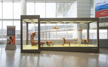 三把木椅子，一个现代摇马和一把椅子在大窗户前面的玻璃椅。