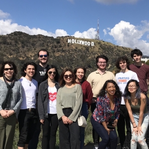 学生和教师在他们的洛杉矶，加利福尼亚州的旅行期间在好莱坞标志前面的一张照片的姿势。