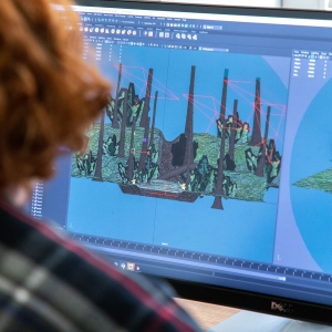 一个学生在游戏艺术课程中使用电脑创建一个动画项目。