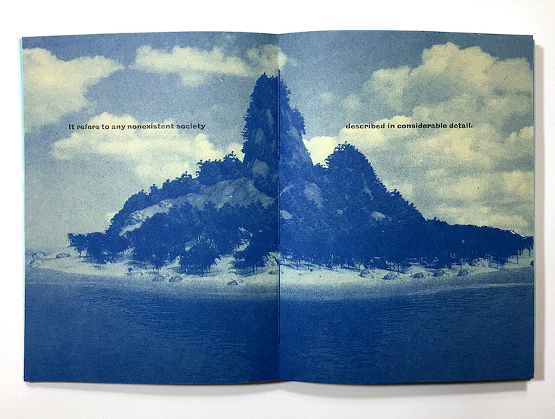 “乌托邦”是教师成员莎拉尼科尔的印刷工作。这是一本书展开的书，展示了蓝色墨水的岛屿的印刷品。页面上的文本读取“它是指在相当细节中描述的任何不存在的社会”